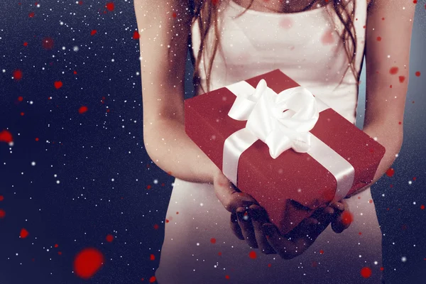 Immagine composita di donna con in mano un regalo rosso e bianco — Foto Stock