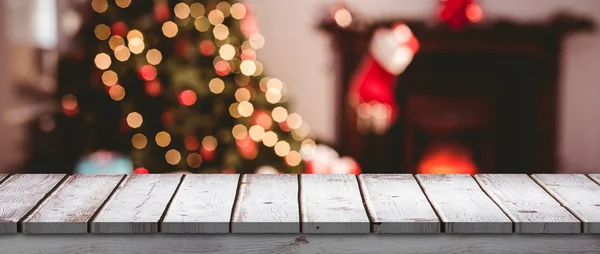 Деревянный стол против рождественских огней — стоковое фото