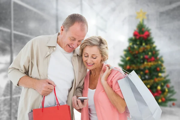 Casal com sacos de compras e smartphone — Fotografia de Stock