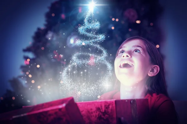 Mädchen öffnet magisches Weihnachtsgeschenk — Stockfoto
