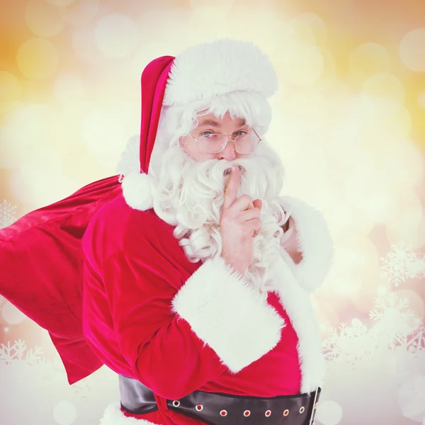 Papai Noel mantendo um segredo e segurando seu saco — Fotografia de Stock