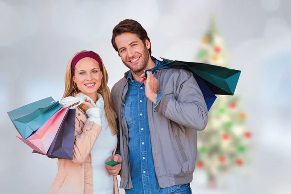 Lachende paar met shopping tassen — Stockfoto