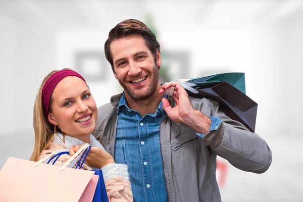 Lachende paar met shopping tassen — Stockfoto