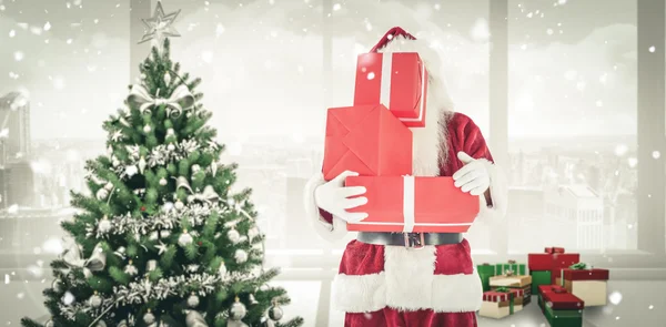 Santa cubre su cara con regalos — Foto de Stock