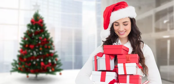 Festive brunette holding pile of gifts — Stock Photo, Image