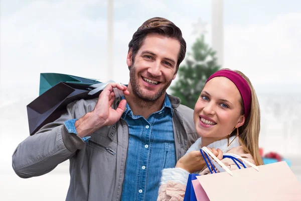 Lachende paar met shopping tassen — Stockfoto