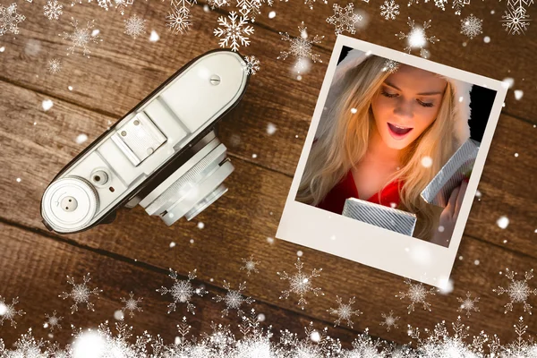 Blondin i santa outfit öppning present — Stockfoto