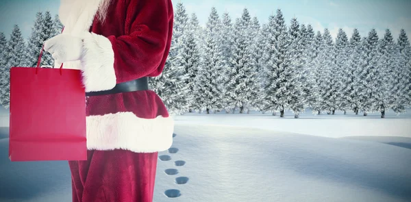 Composite image of santa carries red gift bag — Stock Photo, Image