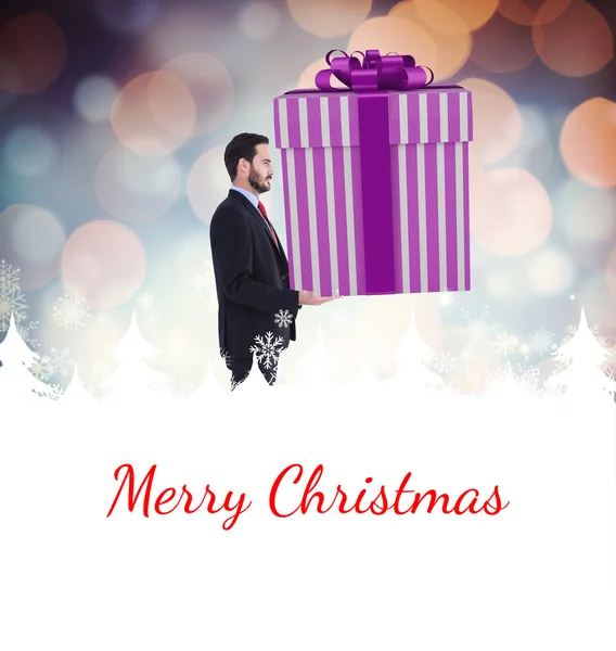 Composite image of stylish man with giant gift — Stock Photo, Image