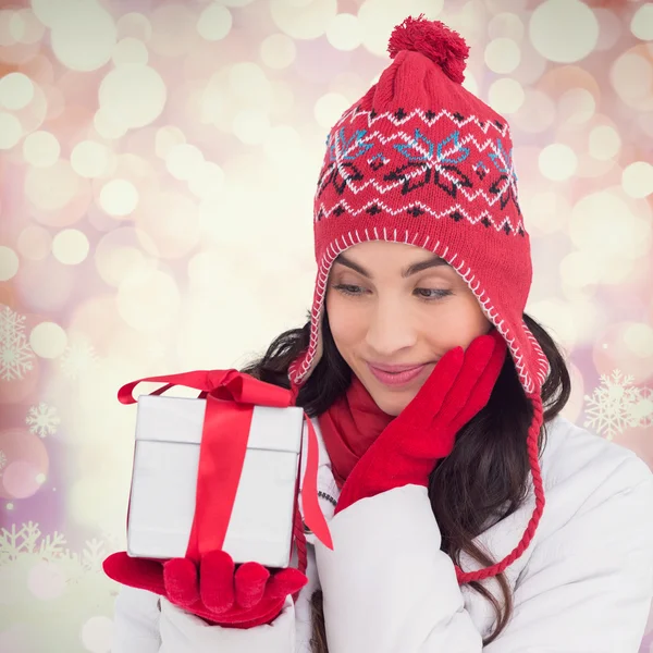 Imagen compuesta de contenido morena en ropa de invierno sosteniendo gi —  Fotos de Stock