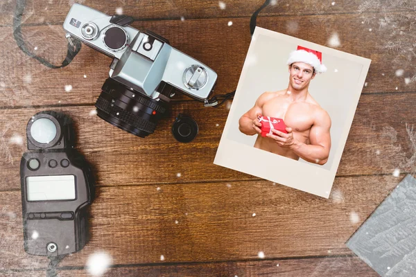 Mann mit Weihnachtsmannhut hält Geschenk in der Hand — Stockfoto