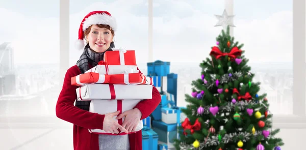 Leende kvinna som håller julklappar — Stockfoto