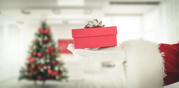 Ręka Świętego Mikołaja trzyma prezent — Zdjęcie stockowe