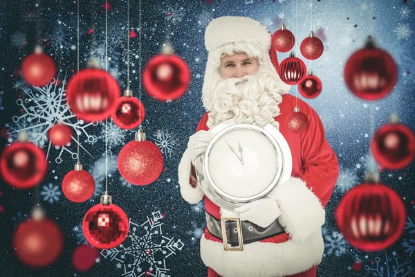Glücklicher Weihnachtsmann, der eine Uhr hält — Stockfoto