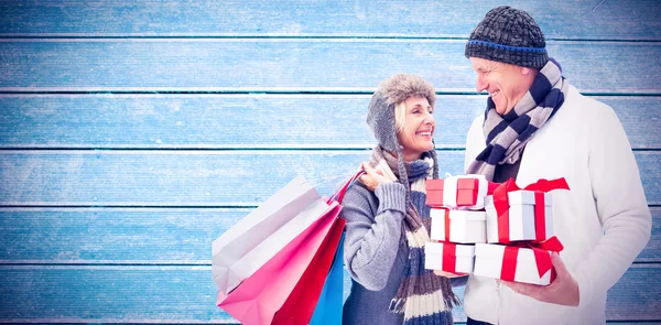 Mature couple holding christmas gifts — Stock Photo, Image