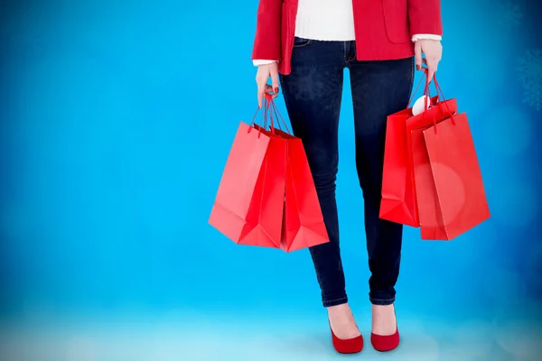 Morena en ropa de invierno sosteniendo bolsas de compras — Foto de Stock