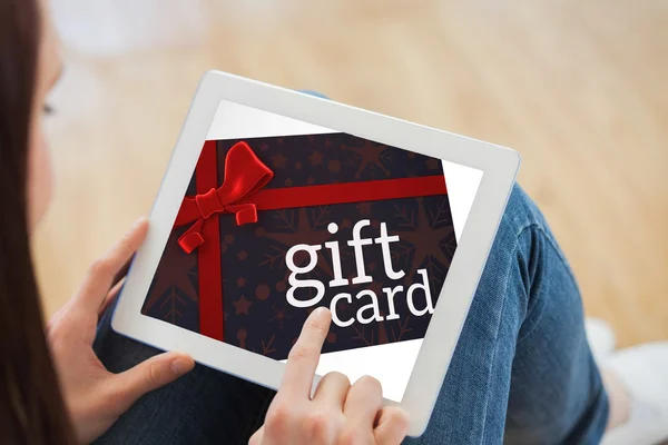 Composite image of teen using a tablet pc sitting on the floor — Stock Photo, Image