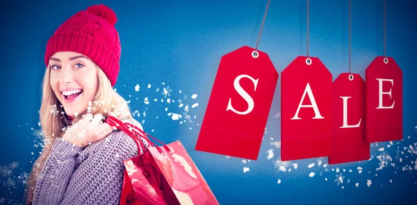 Festive blonde holding shopping bags — Stock Photo, Image