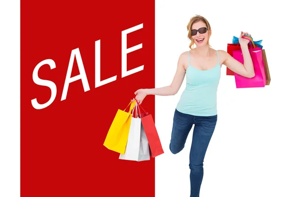 Happy blonde holding shopping bags — Stock Photo, Image