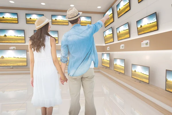 Пара смотрит против телевизоров на продажу — стоковое фото