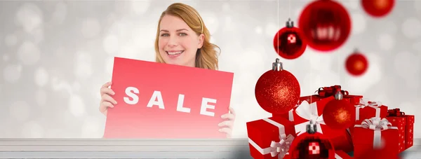 Cute blonde showing a red sale poster — Stock Photo, Image