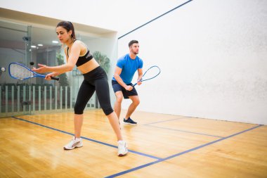 Couple playing some squash together clipart