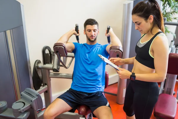 Concentrating man using weights machine — Stock Photo, Image