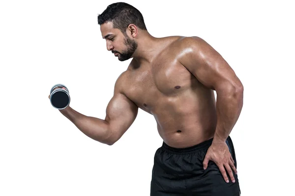 Homem muscular levantando halteres pesados — Fotografia de Stock