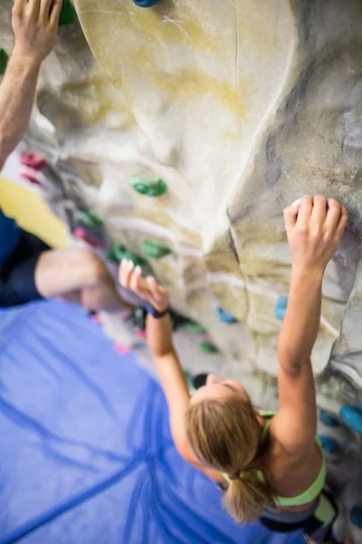 Fit woman rock climbing indoors — Stock Photo, Image