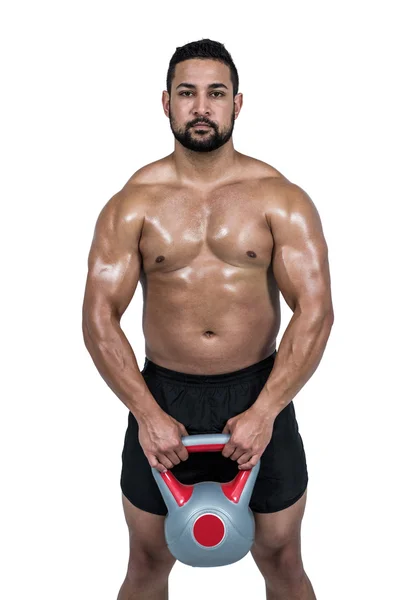 Homem muscular levantando kettlebell pesado — Fotografia de Stock