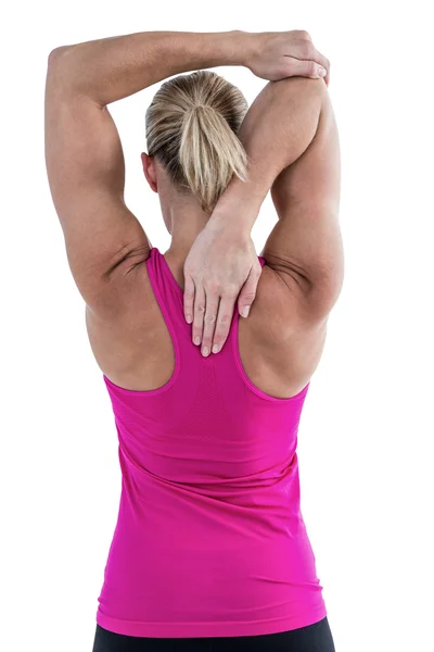 Vista trasera de la mujer musculosa estirando el brazo — Foto de Stock