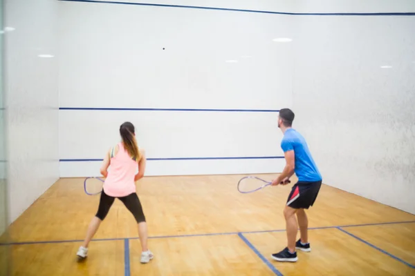 Couple playing some squash together — Stock Photo, Image