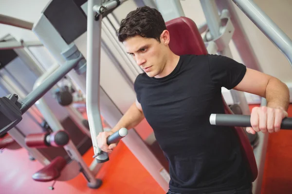 Fit homem usando máquina de pesos — Fotografia de Stock