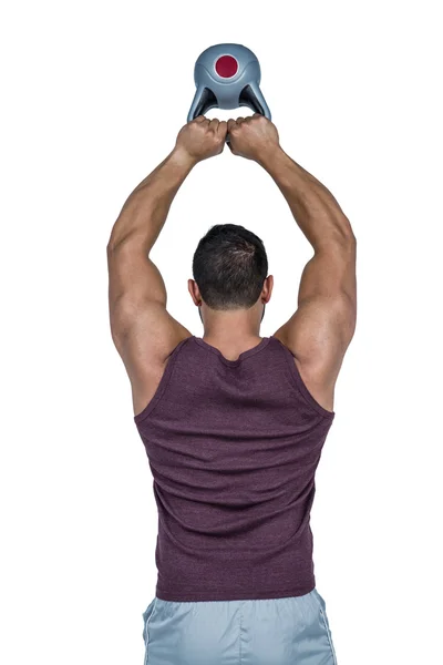 Homme sérieux soulevant une kettlebell — Photo