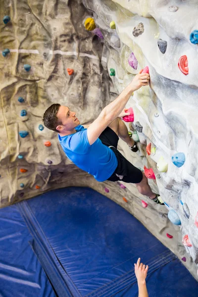 Fitter Mann klettert drinnen — Stockfoto