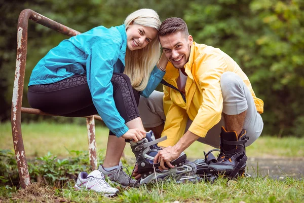 Couple putting on roller blades — Stock Photo, Image