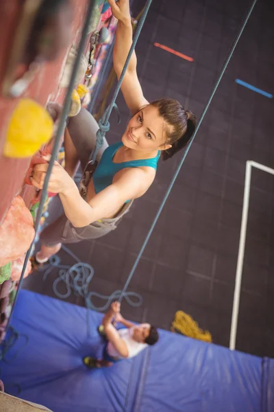 Woman climbing up rock wall — Stock Photo, Image