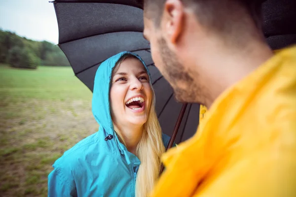 Couple on a hike under umbrella — Stock Photo, Image