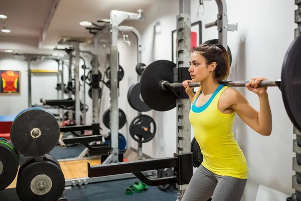 Vastberaden vrouw opheffing van een barbell — Stockfoto