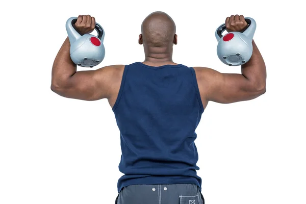 Homem muscular exercitando com kettlebells — Fotografia de Stock