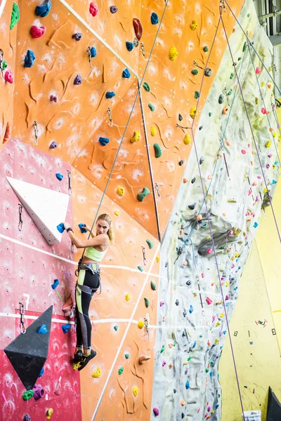 Blonde rock climbing indoors — Stock Photo, Image