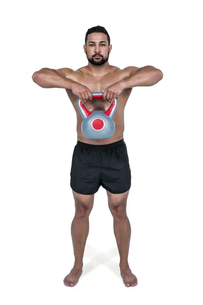 Homem muscular levantando kettlebell pesado — Fotografia de Stock