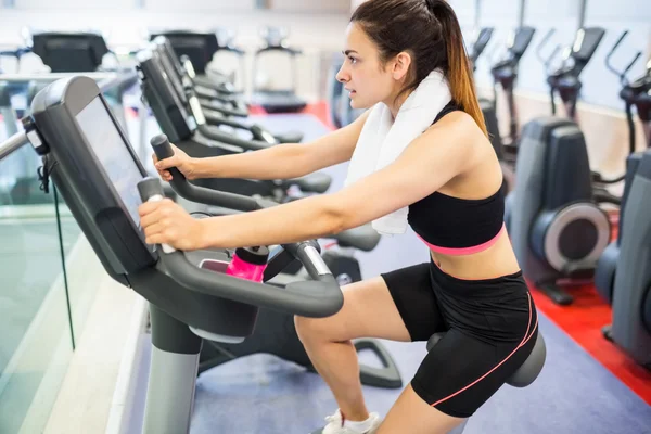 Mulher usando a bicicleta de exercício — Fotografia de Stock