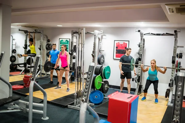 Fit people working out in weights room — Stock Photo, Image