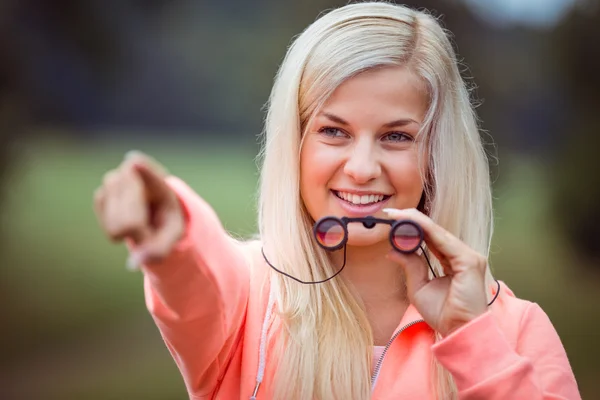 Blondin tittar genom kikare — Stockfoto