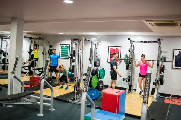 Fit people working out in weights room — Stock Photo, Image