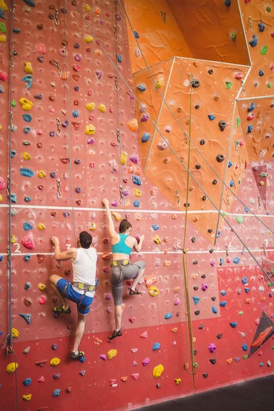 Couple climbing up rock wall — Stock Photo, Image