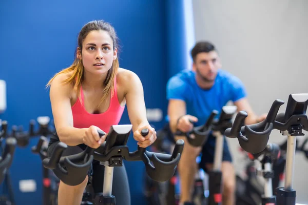 Uomo e donna che utilizzano cyclette — Foto Stock