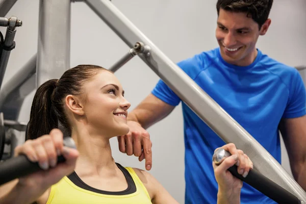 Woman using weights machine — Stock Photo, Image