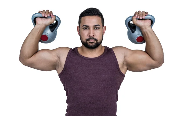 Homem sério levantando kettlebells — Fotografia de Stock